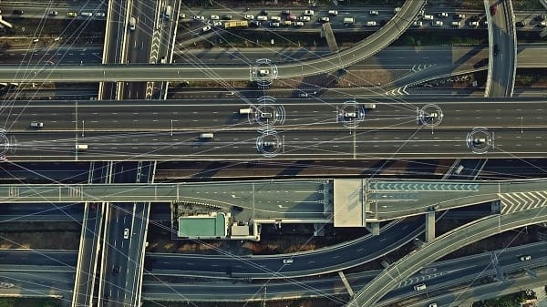 Aerial view from above of traffic on the elevated expressway with futuristic autonomous, driverless cars using artificial intelligence computer network and satellite gps for navigation